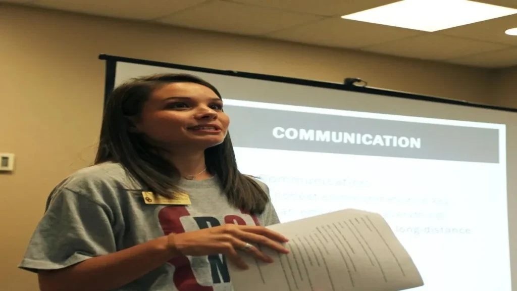A college professor and student engaged in a one-on-one writing discussion in a university office.